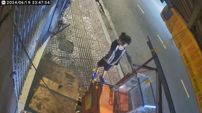 Bé trai đưa chiếc điện thoại lên hướng camera an ninh sau khi phát hiện chủ tiệm để quên