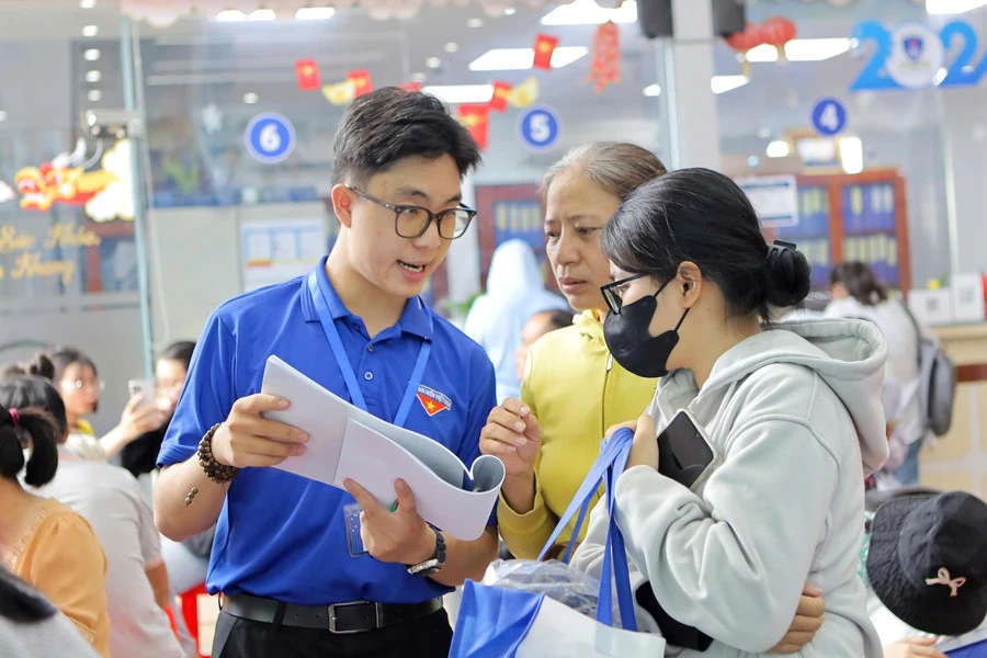 Sinh viên tình nguyện tại Trường Đại học Nguyễn Tất Thành hỗ trợ tân sinh viên làm thủ tục nhập học, sáng 19/8. Ảnh: NTTU