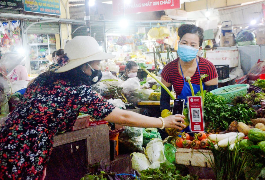 Người dân mua sắm và thanh toán tiền qua hình thức quét mã QR Code tại chợ Thắng Nhất (TP Vũng Tàu, Bà Rịa - Vũng Tàu). Ảnh minh họa: INT