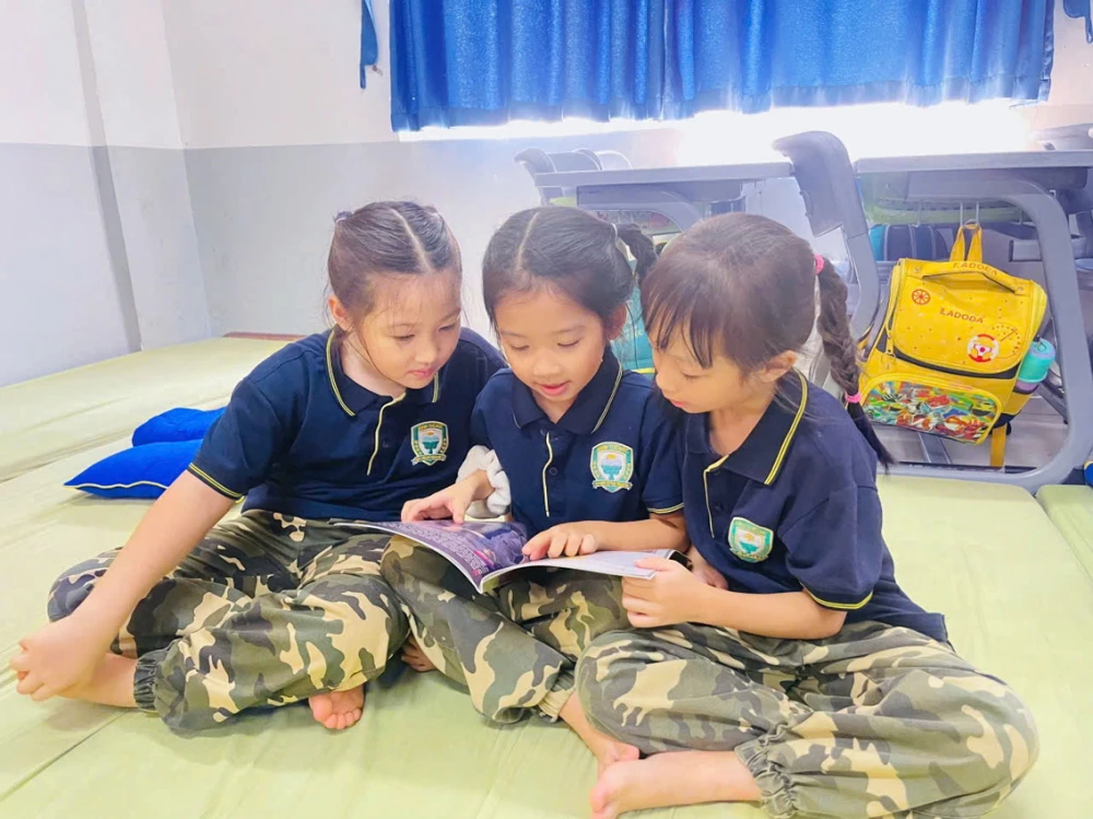 Bé Nguyễn Hoàng Quỳnh Anh (giữa) đọc sách cùng các bạn - Ảnh do gia đình nhân vật cung cấp