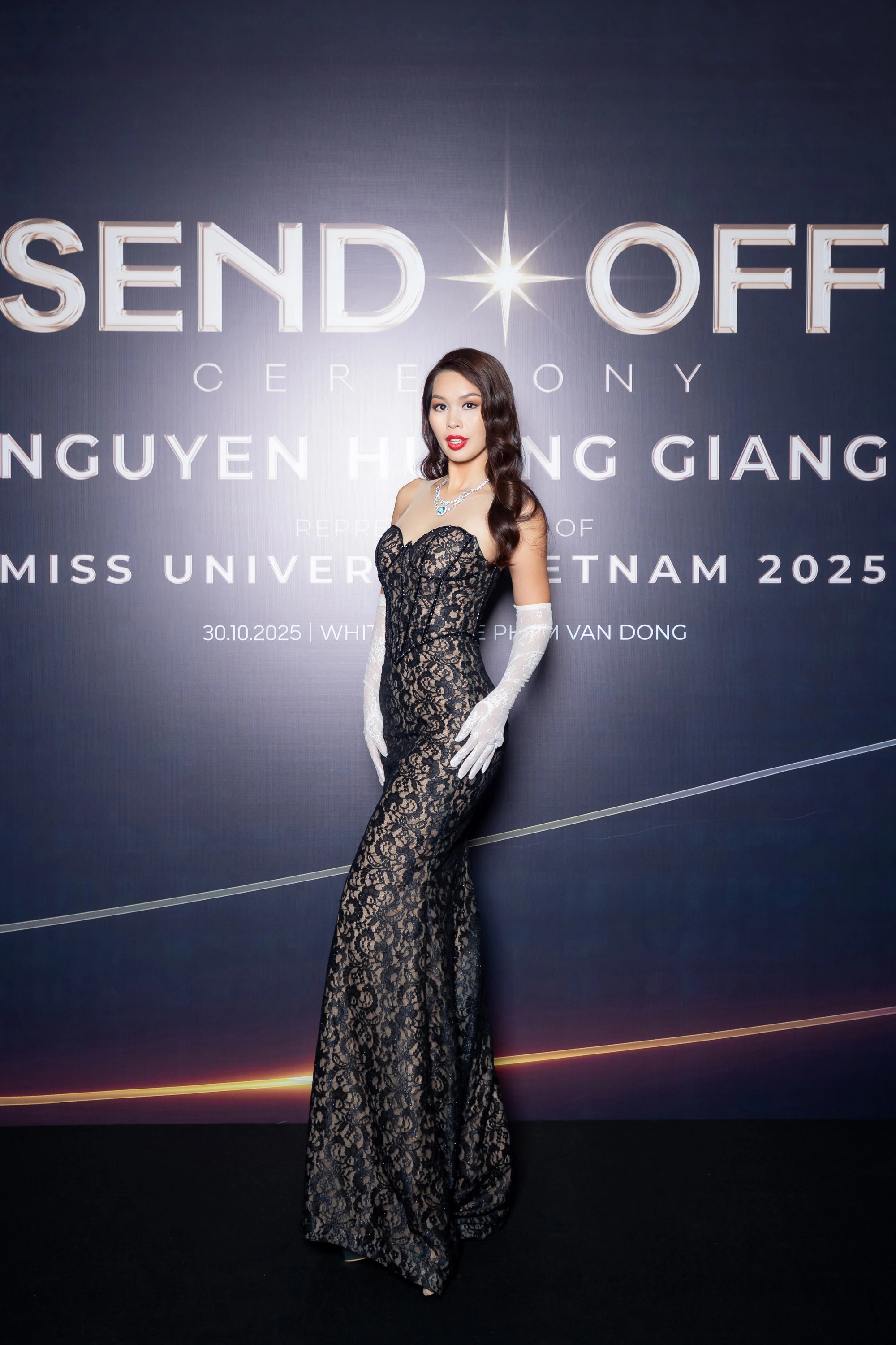 Hà Anh diện đầm ren đen dáng ôm sát khoe trọn đường cong gợi cảm, kết hợp găng tay ren trắng tinh tế. Mái tóc uốn lọn bồng bềnh, son đỏ rực và trang sức ánh bạc càng làm nổi bật vẻ nữ tính, quyền lực và tự tin của nữ diễu mẫu.