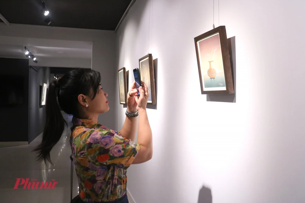 Triển lãm “CHUNG 3+1”: Sức sống mới của nghệ thuật đương đại Việt Nam Khách tham dự ghi lại khoảnh khắc bên các tác phẩm lụa của họa sĩ Lâm Gia Huấn - Ảnh: Phương Nhã