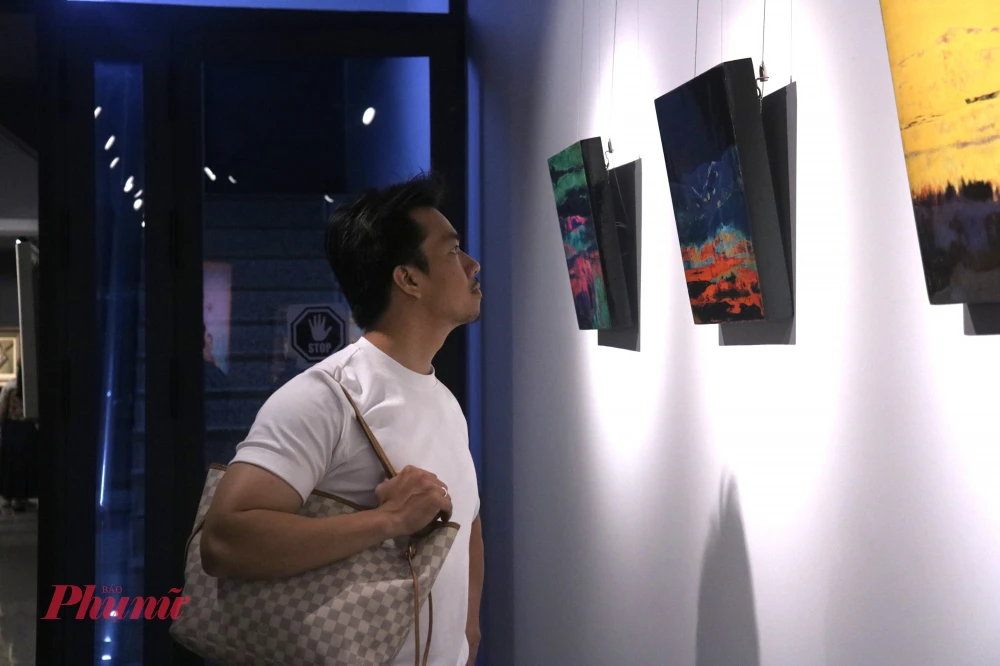 Triển lãm “CHUNG 3+1”: Sức sống mới của nghệ thuật đương đại Việt Nam Người xem thưởng thức các tác phẩm sơn mài của họa sĩ Long Trần - Ảnh: Phương Nhã