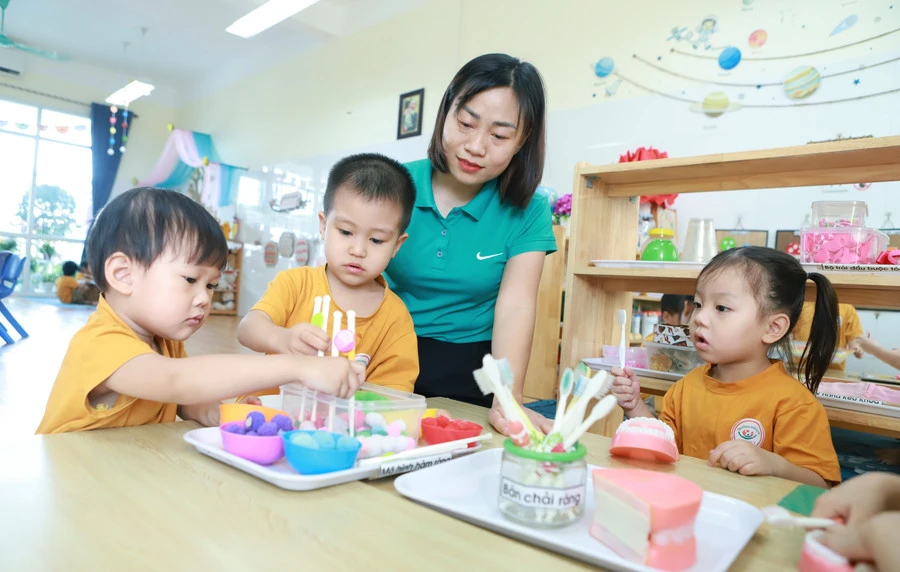 Trẻ tại Trường Mầm non An Khánh B (An Khánh, Hà Nội) trong một hoạt động góc dưới sự hướng dẫn của cô giáo. Ảnh: Đình Tuệ