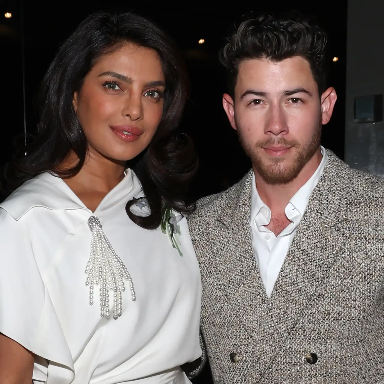  Cặp đôi Priyanka Chopra và Nick Jonas luôn thể hiện phong cách thanh lịch, sang trọng và cuốn hút khi xuất hiện cùng nhau. Priyanka Chopra diện thiết kế váy trắng với phom dáng mềm mại và chi tiết trang trí ngọc trai rủ xuống phần cổ áo, tạo điểm nhấn tinh tế và nữ tính. Nick Jonas lựa chọn bộ suit màu trung tính với chất liệu vải tweed cổ điển, kết hợp áo sơ mi trắng đơn giản, mang đến vẻ lịch lãm và hiện đại.