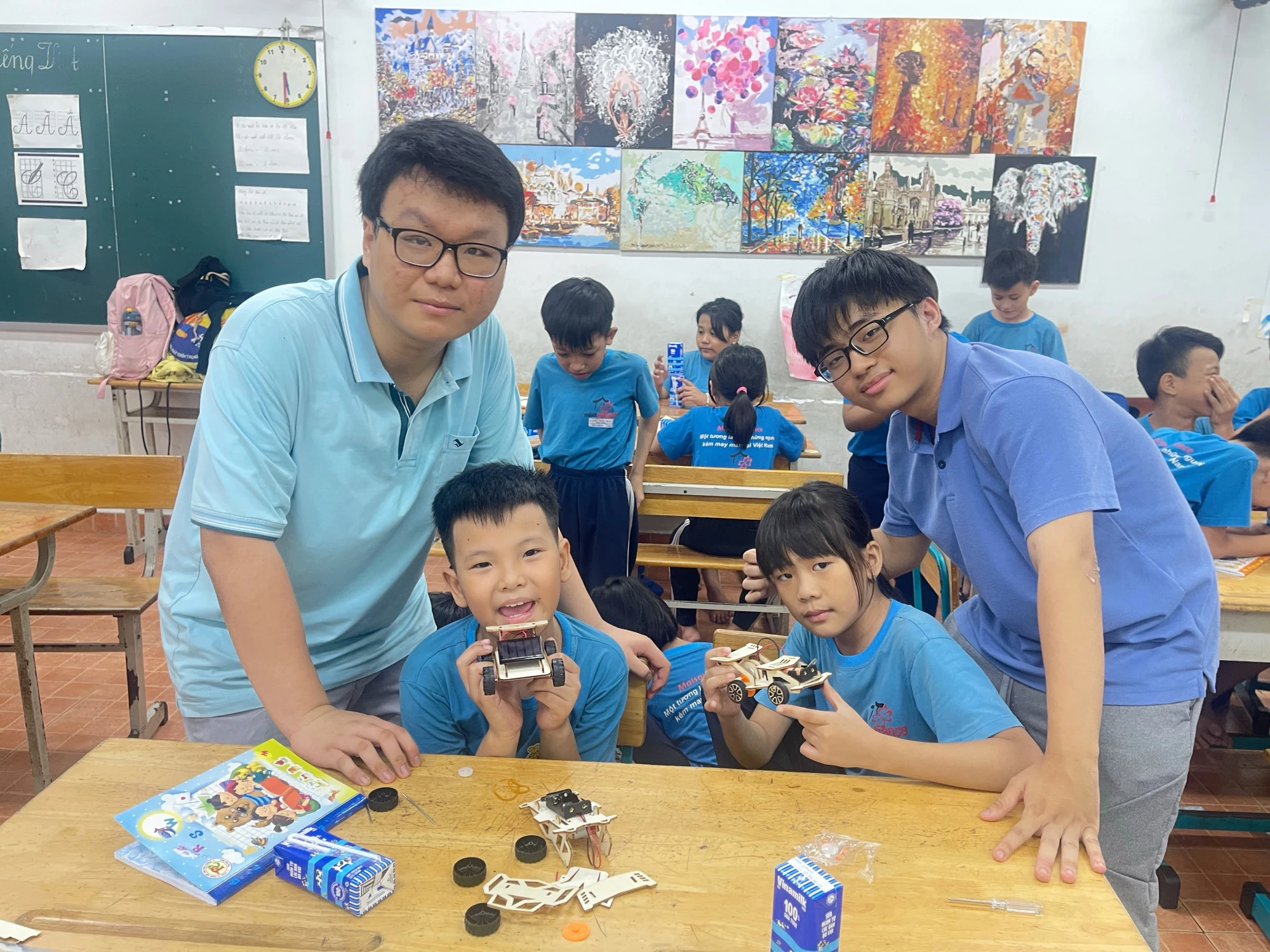 Quang Thắng (bên trái) tham gia dạy Lý + Lắp ráp mô hình xe năng lượng mặt trời - Ảnh: NVCC